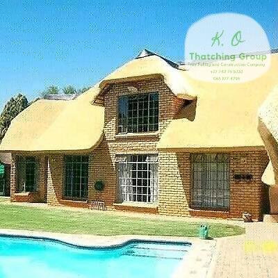Brick poolside home with a sculpted golden thatch roof